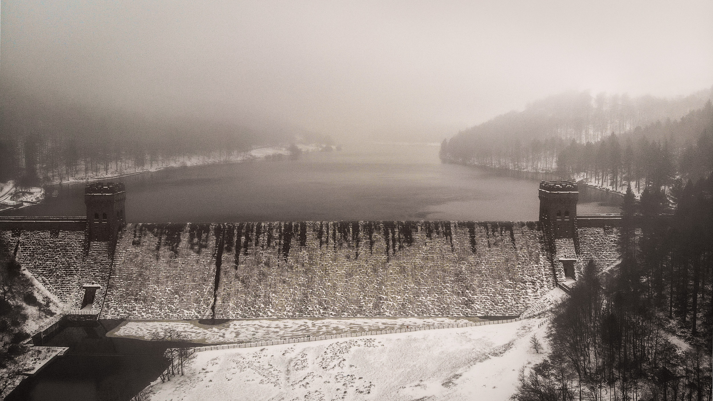 Derwent Dam Winter Print featuring the iconic twin towers  in the Peak District during snowfall.